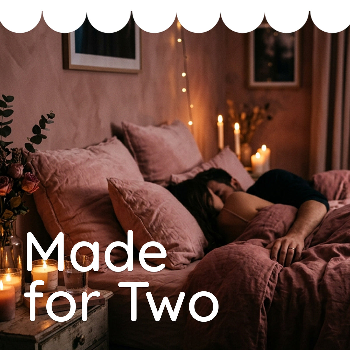 A couple lying together on a bed in a warmly lit bedroom, with pink bedding, candles, and the overlaid text 'Made for Two'.