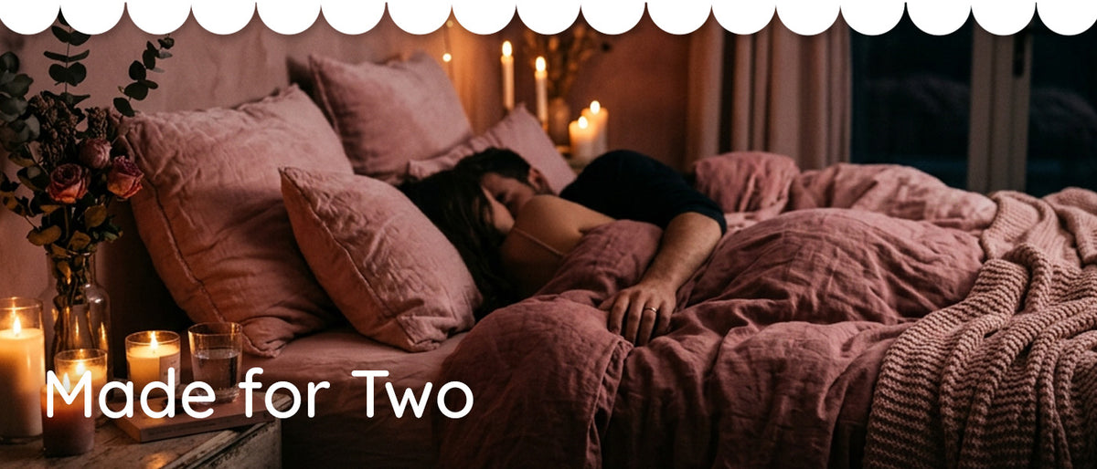 Made for two - couples pleasure toys. WHat's your vibe? A woman lies asleep on a bed with pink bedding and pillows in a dimly lit bedroom with candles. White scalloped trim appears at the top, and the text 'Made for Two' is overlaid at the bottom left.